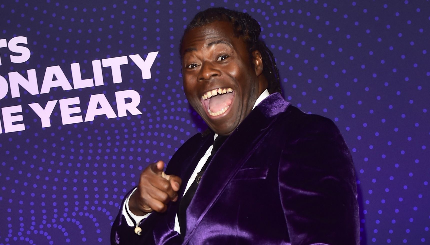 Ade Adepitan in purple suit
