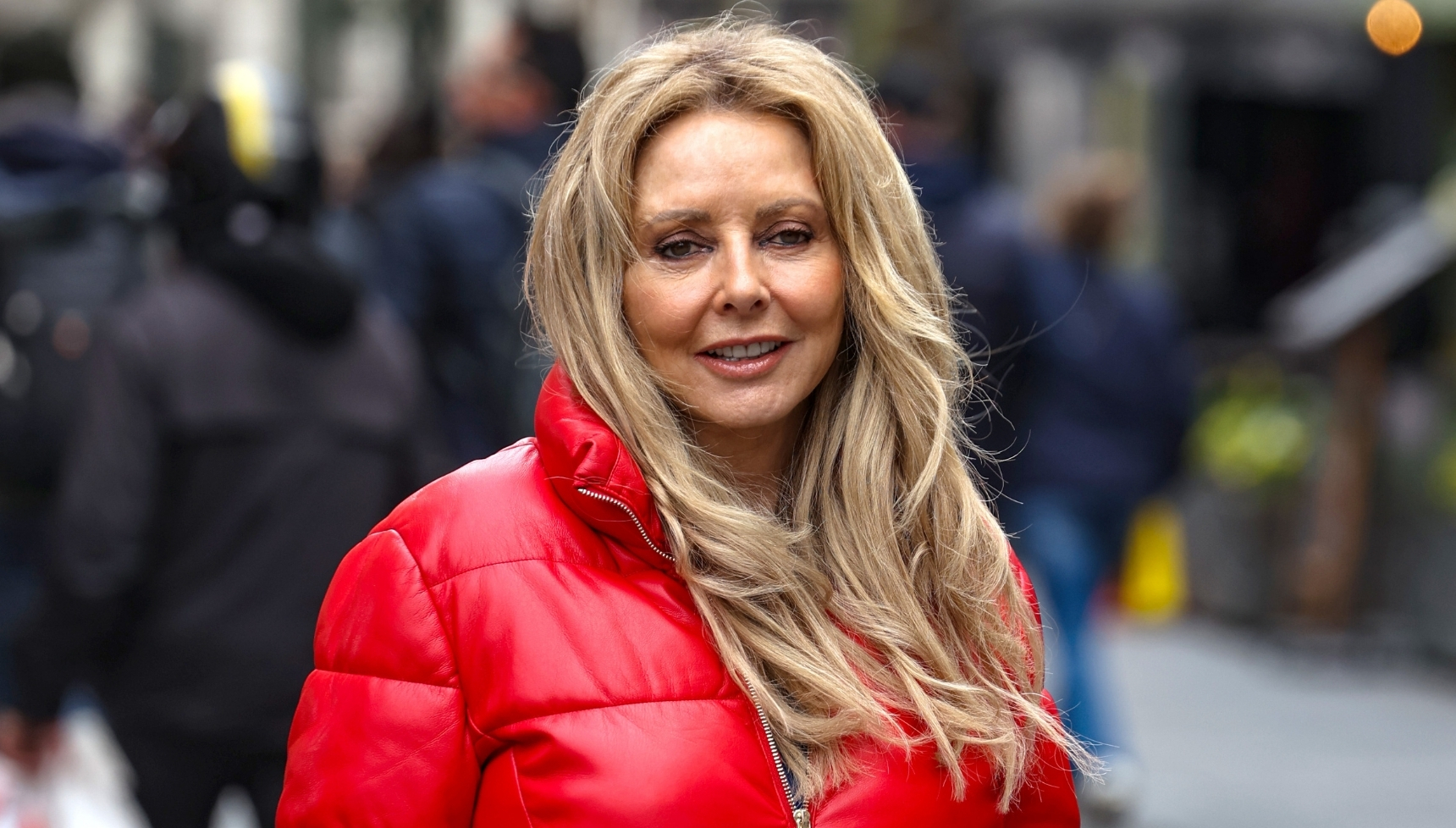 Carol Vorderman smiling in red coat