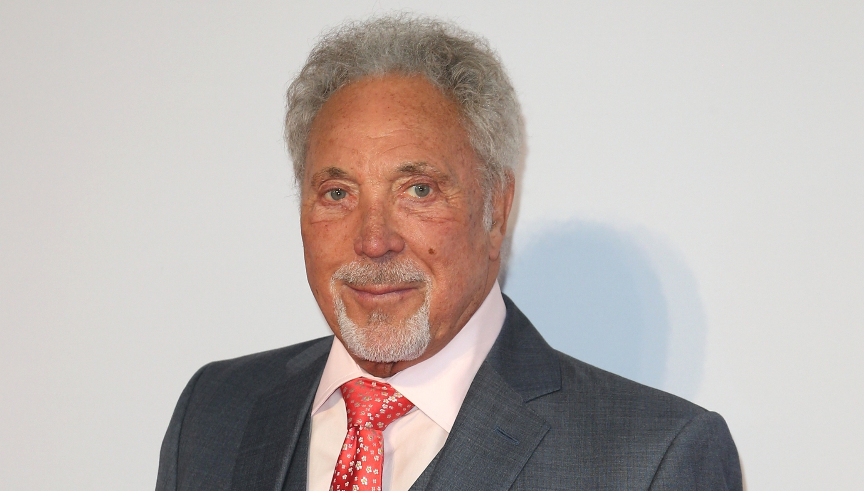 Tom Jones smiling in suit at event