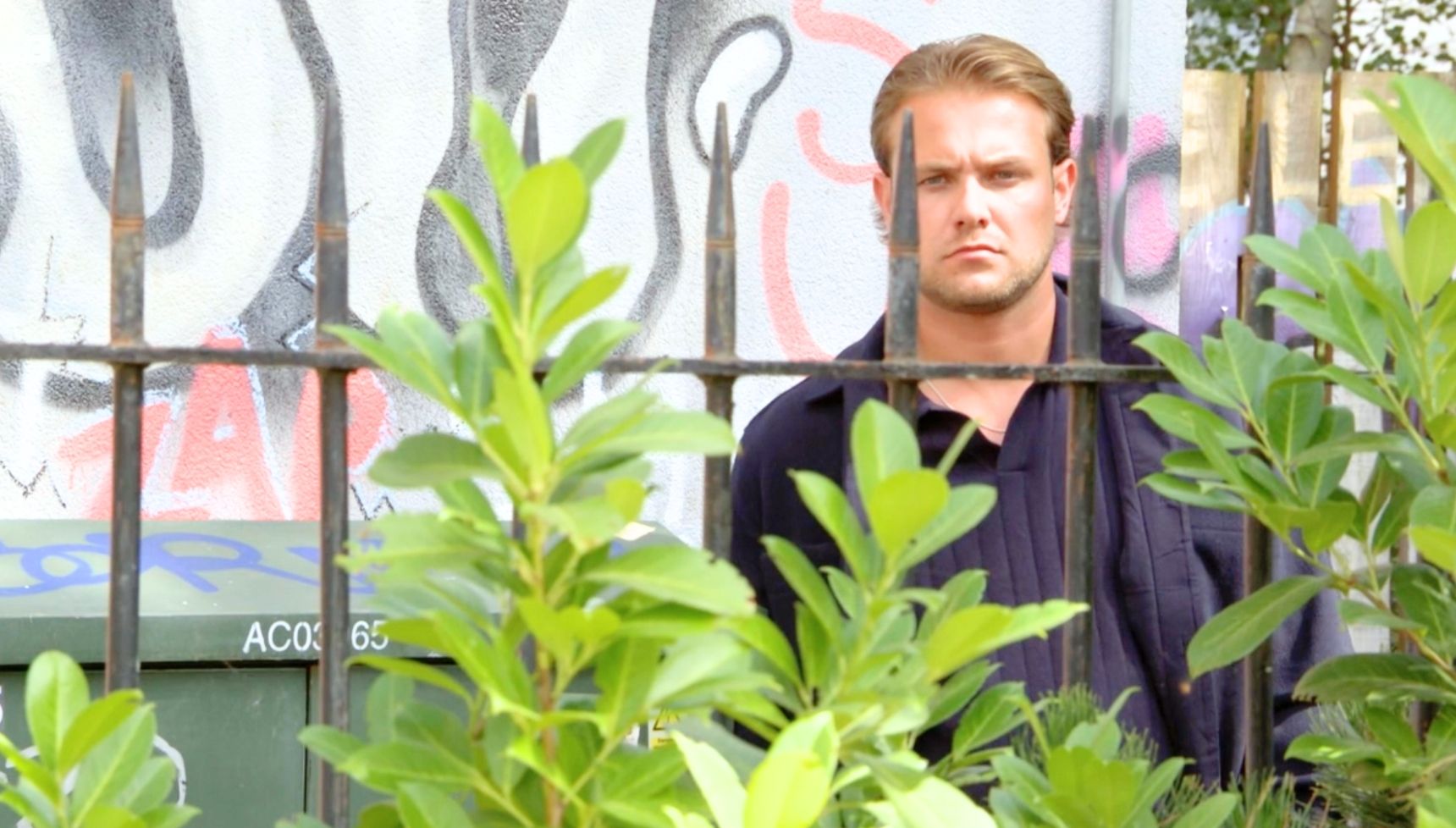 Craig hiding in the bushes in EastEnders (Credit: BBC)